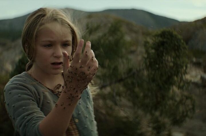 Isla (Alix West Lefler) holds up a hand covered in bees